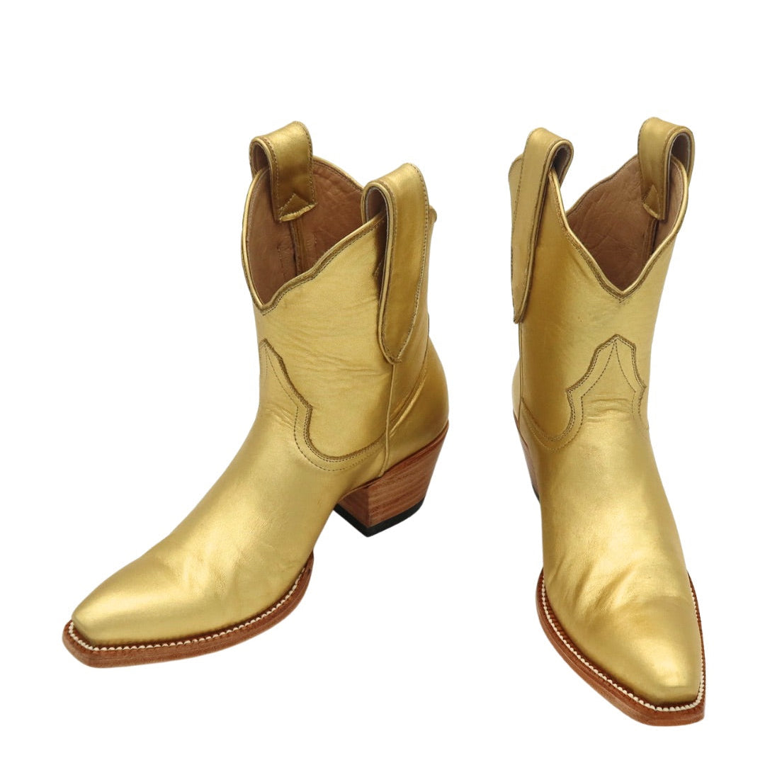 Pair of gold luxury cowgirl cowboy boots on a white background
