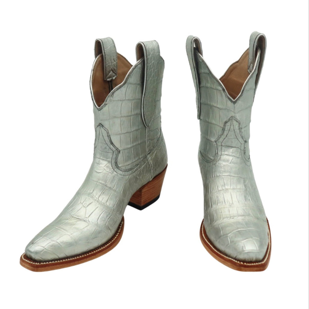 Pair of luxury silver alligator cowgirl / cowboy boots on a white background