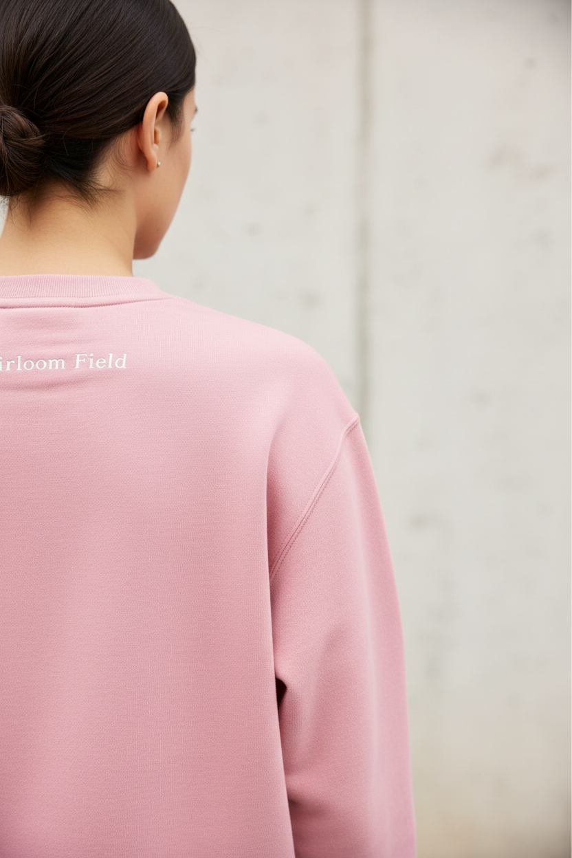 Person wearing a pink sweatshirt with a blurred background