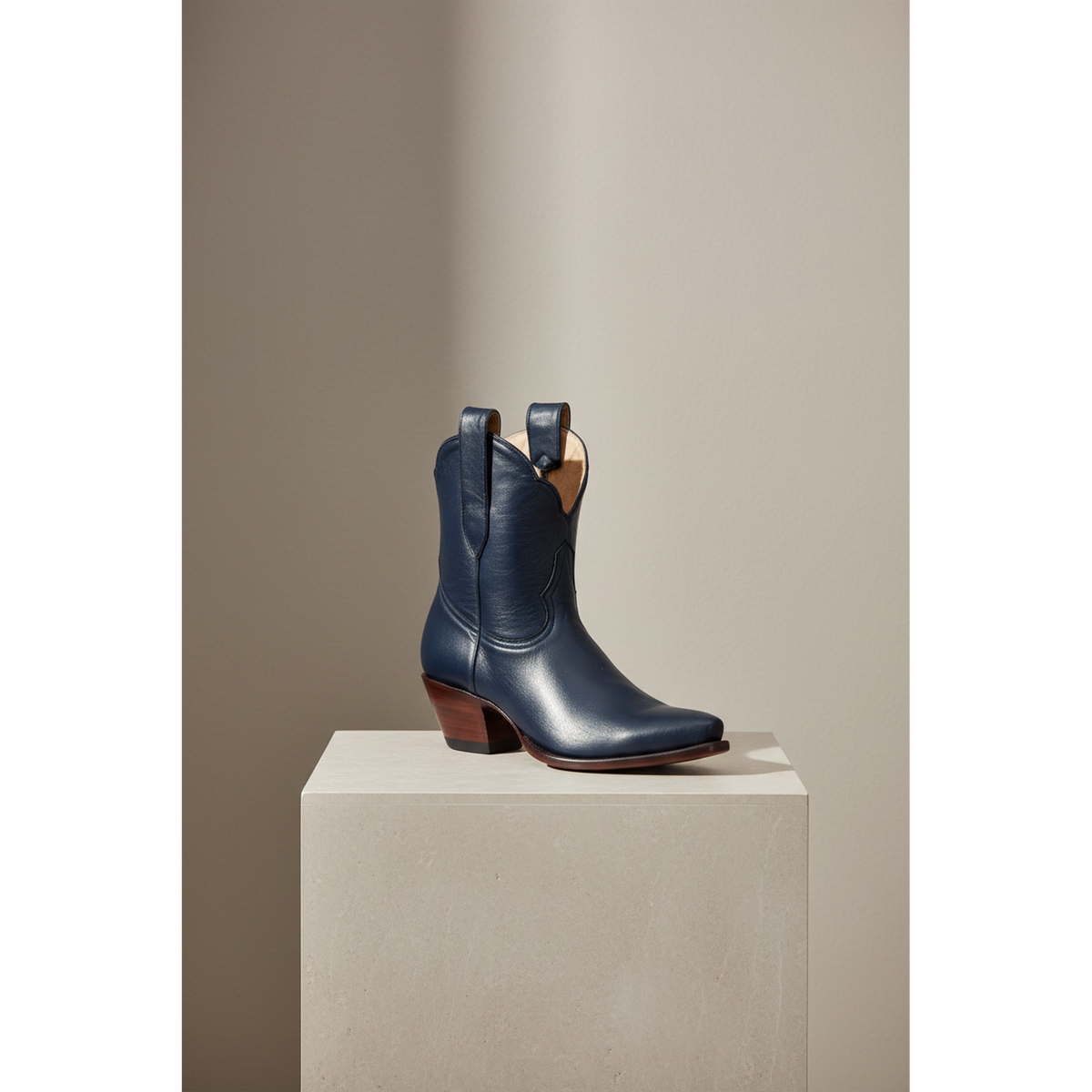 Navy Payton boot, front three-quarter view on a pedestal.