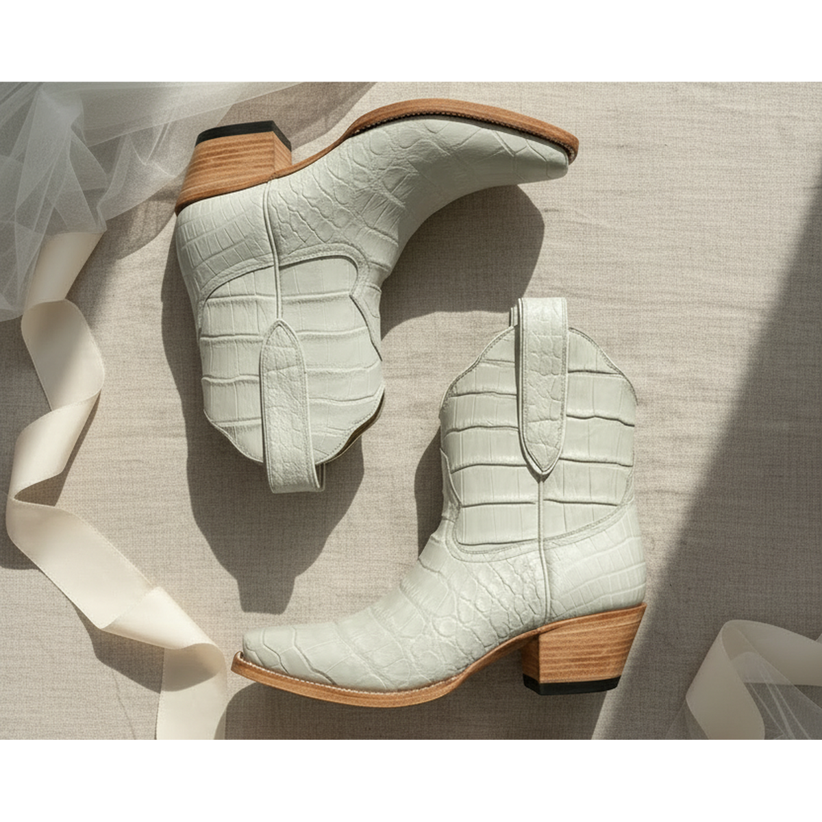 Pair of light gray chalk ivory cream ankle boots with wooden soles on a neutral background tule ribbon bridal alligator exotic short luxury boot cowgirl cowboy white