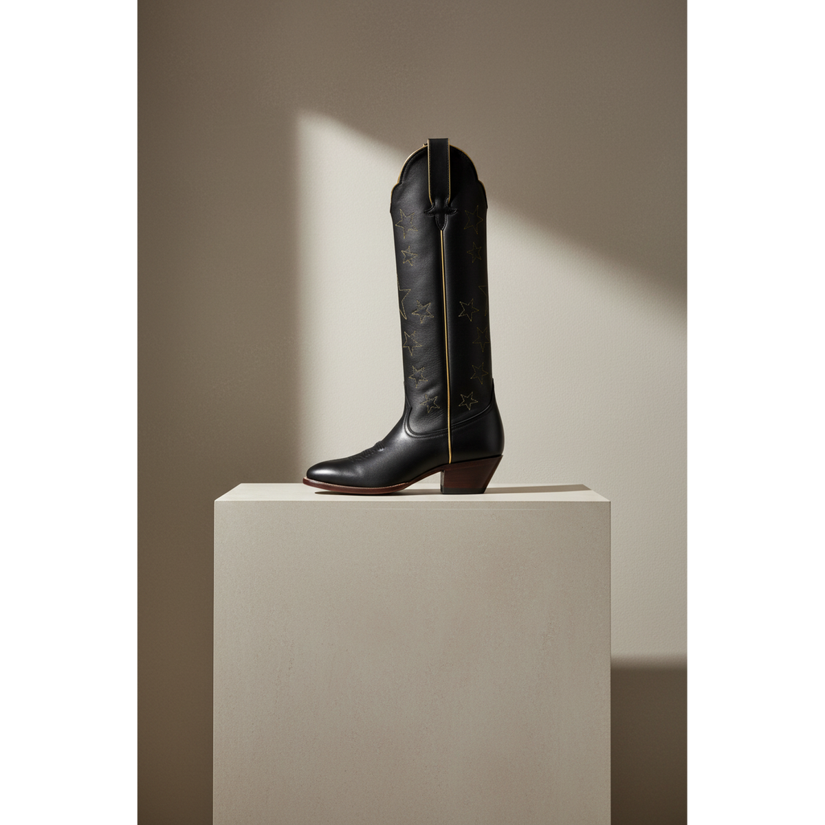 Tall boot displayed on a light pedestal, gallery view 2