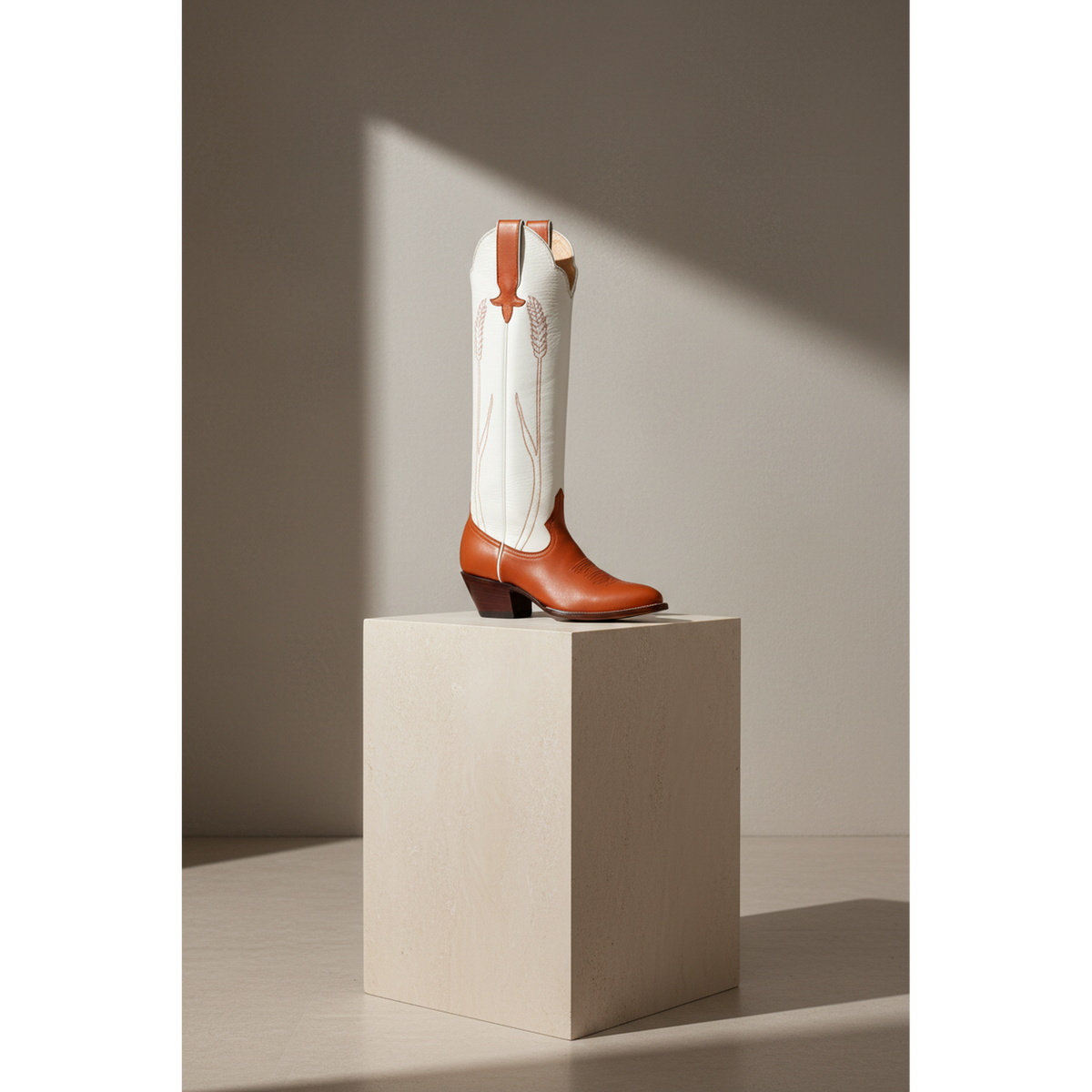 Chestnut and Bone Wheat boot on a pedestal in sunlight