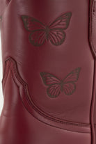 Red Maroon Burgundy Crimson cowgirl cowboy boot with a butterfly design on a white background