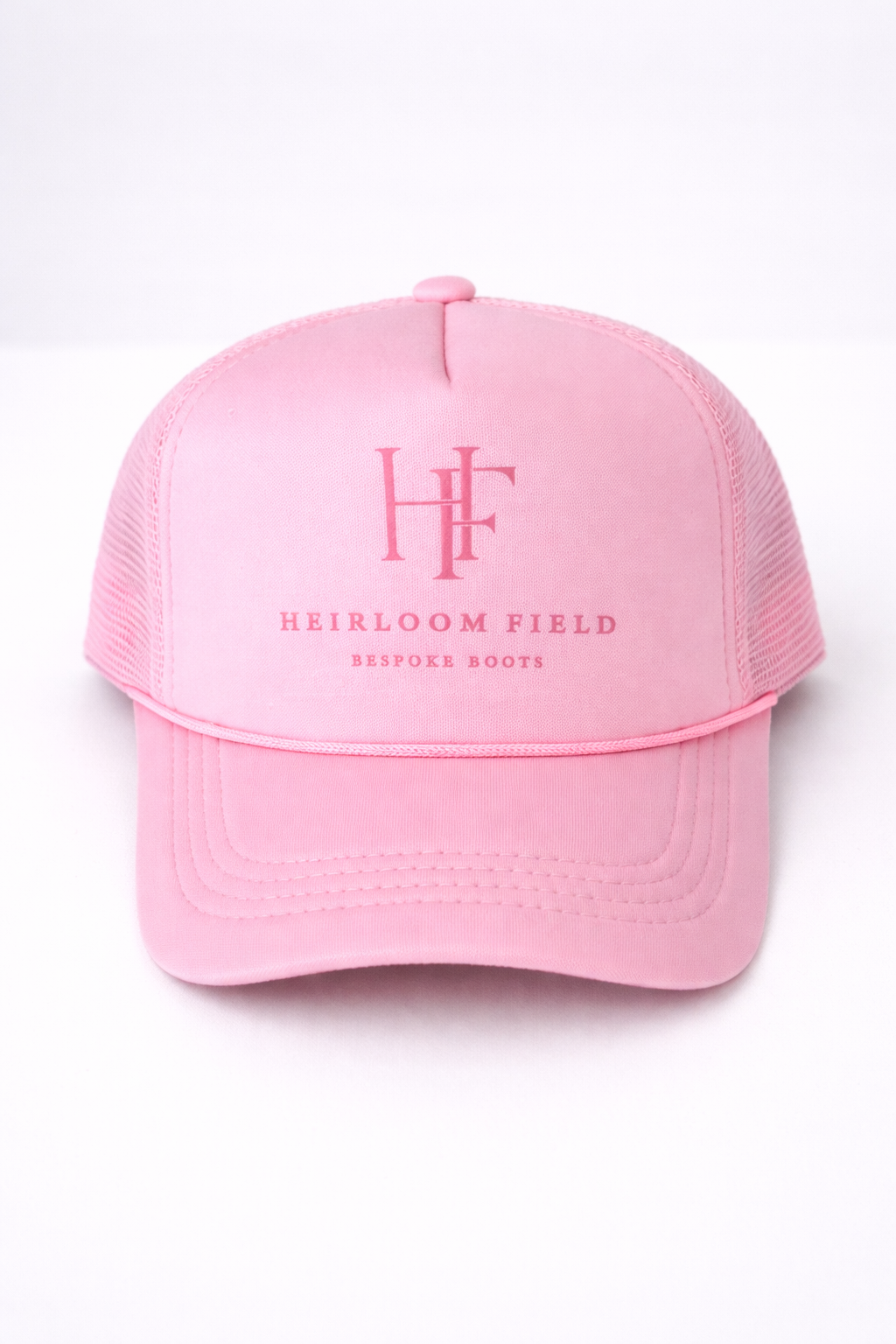 Pink cap with 'Heirloom Field' logo on a white background