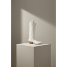 Ivory A-Toe Vine boot displayed on a square pedestal.