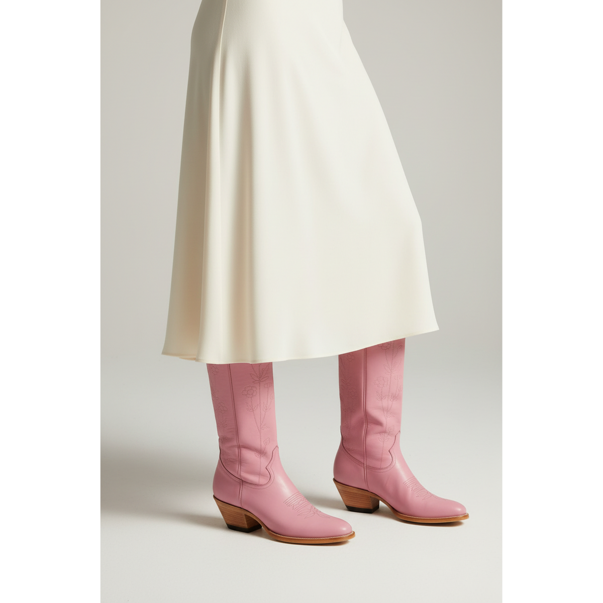 Pink Buttercup boots worn with an ivory skirt