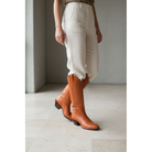 Chestnut tall boots worn with light trousers.