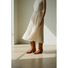 Chestnut tall boots worn with a light dress.