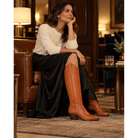 Chestnut tall boots worn while seated indoors.