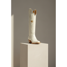 Gold Flower boot displayed in a three-quarter view on a pedestal.