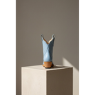 Powder blue boot in rear view on a stone pedestal