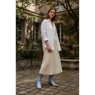 Woman wearing powder blue boots in a courtyard