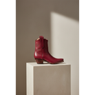 Maroon Mariposa boot in side view on a rectangular pedestal.