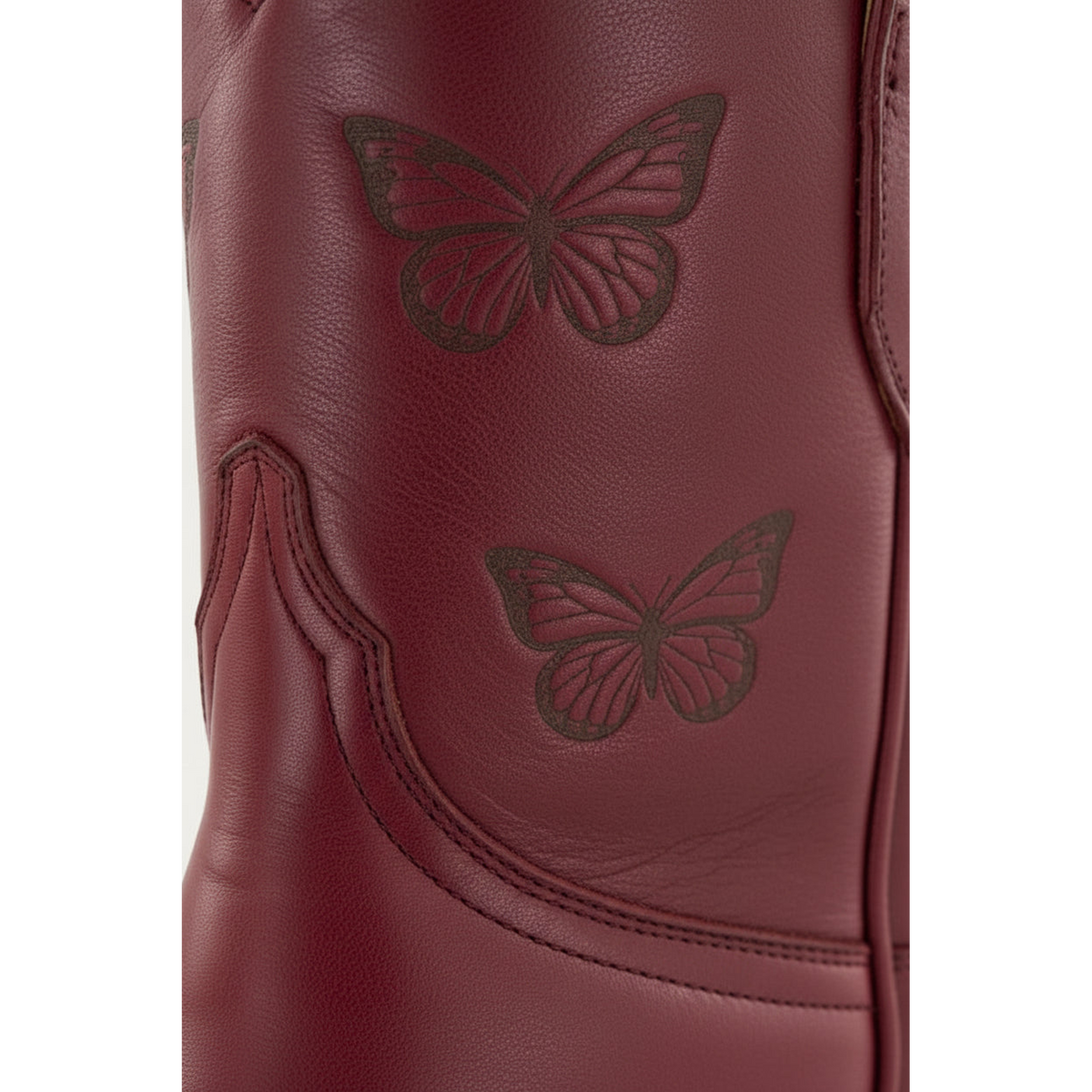 Close-up of butterfly details and stitching on a maroon Mariposa boot.