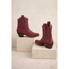 Maroon Mariposa boots arranged on two blocks.