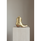 Gold Metallic Payton boot, side view on a stone pedestal