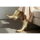 Gold Metallic Payton boots worn with a cream dress