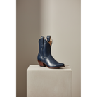 Navy Payton boot, front three-quarter view on a pedestal.