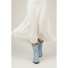 Pale-blue boots beneath a flowing white skirt, shown in a close styling view.