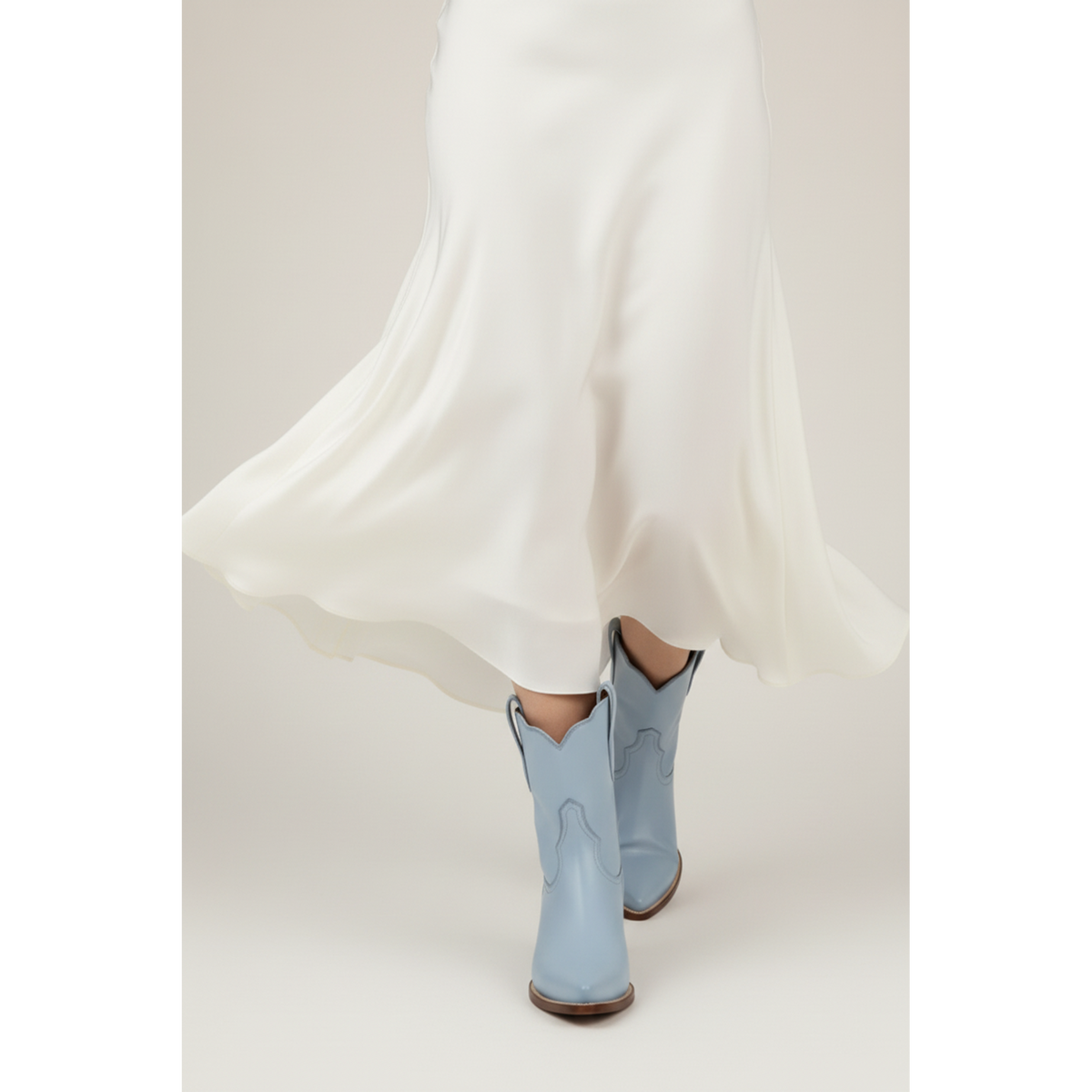 Pale-blue boots beneath a flowing white skirt, shown in a close styling view.