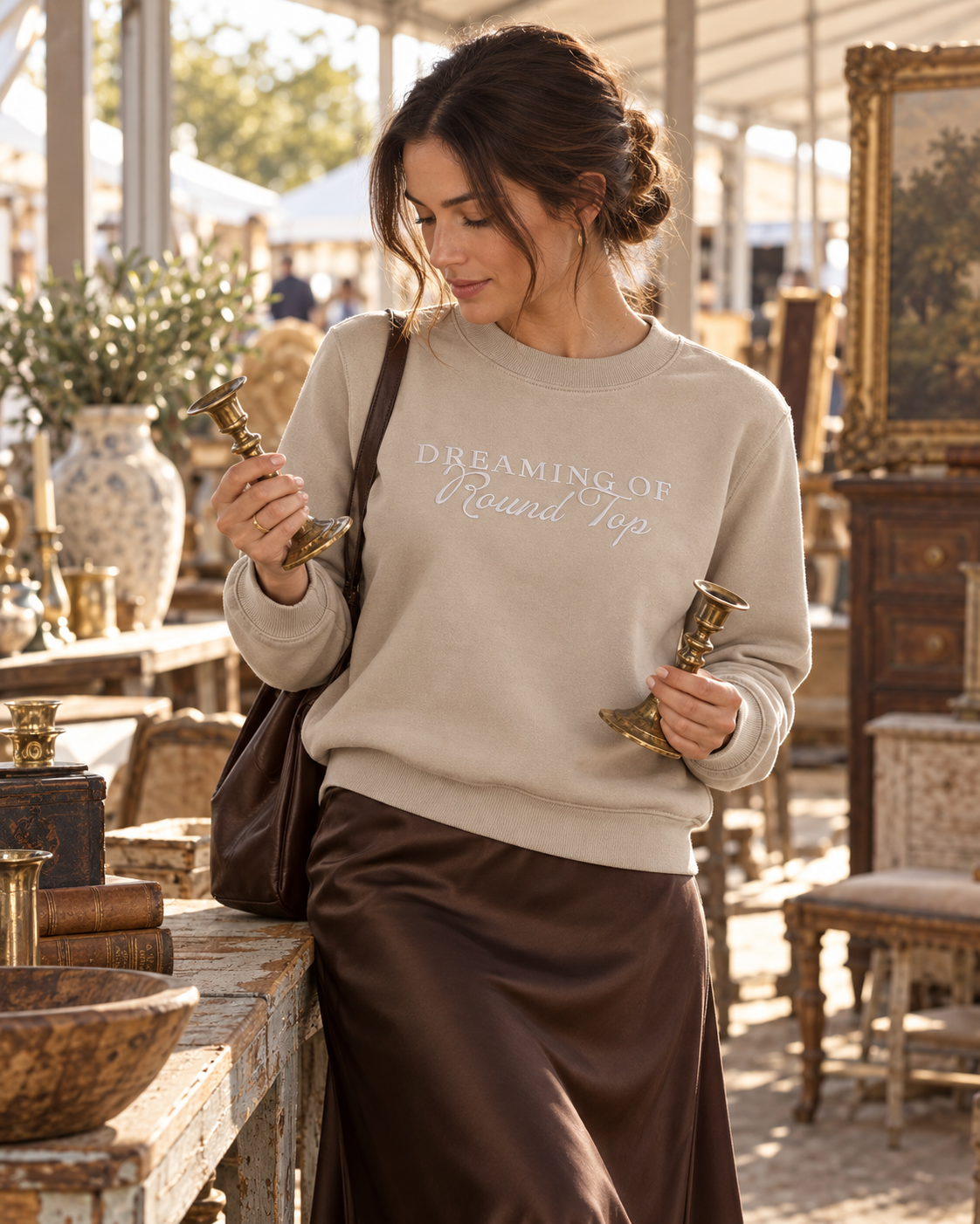 A woman wearing the taupe Dreaming of Round Top sweatshirt while shopping antiques.