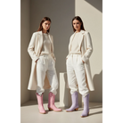 Two women in cream tailoring wearing pink and lavender midi boots.