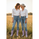 Two women wearing lavender boots with white shirts and blue jeans in a field.