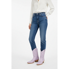 Person wearing blue jeans and lavender cowboy boots on a white background