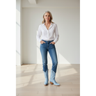 Woman wearing pale-blue boots with a white shirt and blue jeans.