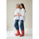 Two women in white shirts and jeans wearing red boots