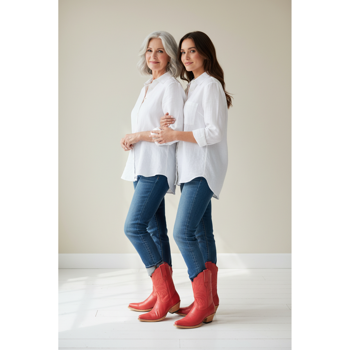 Two women in white shirts and jeans wearing red boots