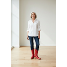 Woman in a white shirt and jeans wearing red boots