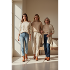 Three women in neutral outfits wearing brown boots.