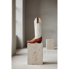 Chestnut and Bone Wheat boot on a stone pedestal