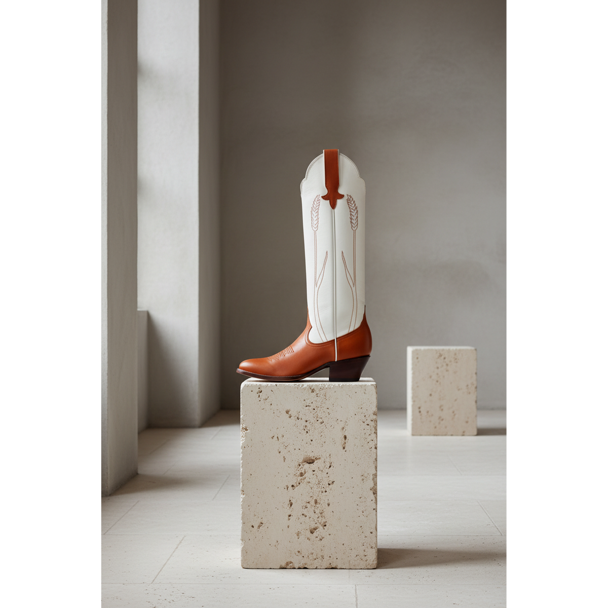 Chestnut and Bone Wheat boot on a stone pedestal